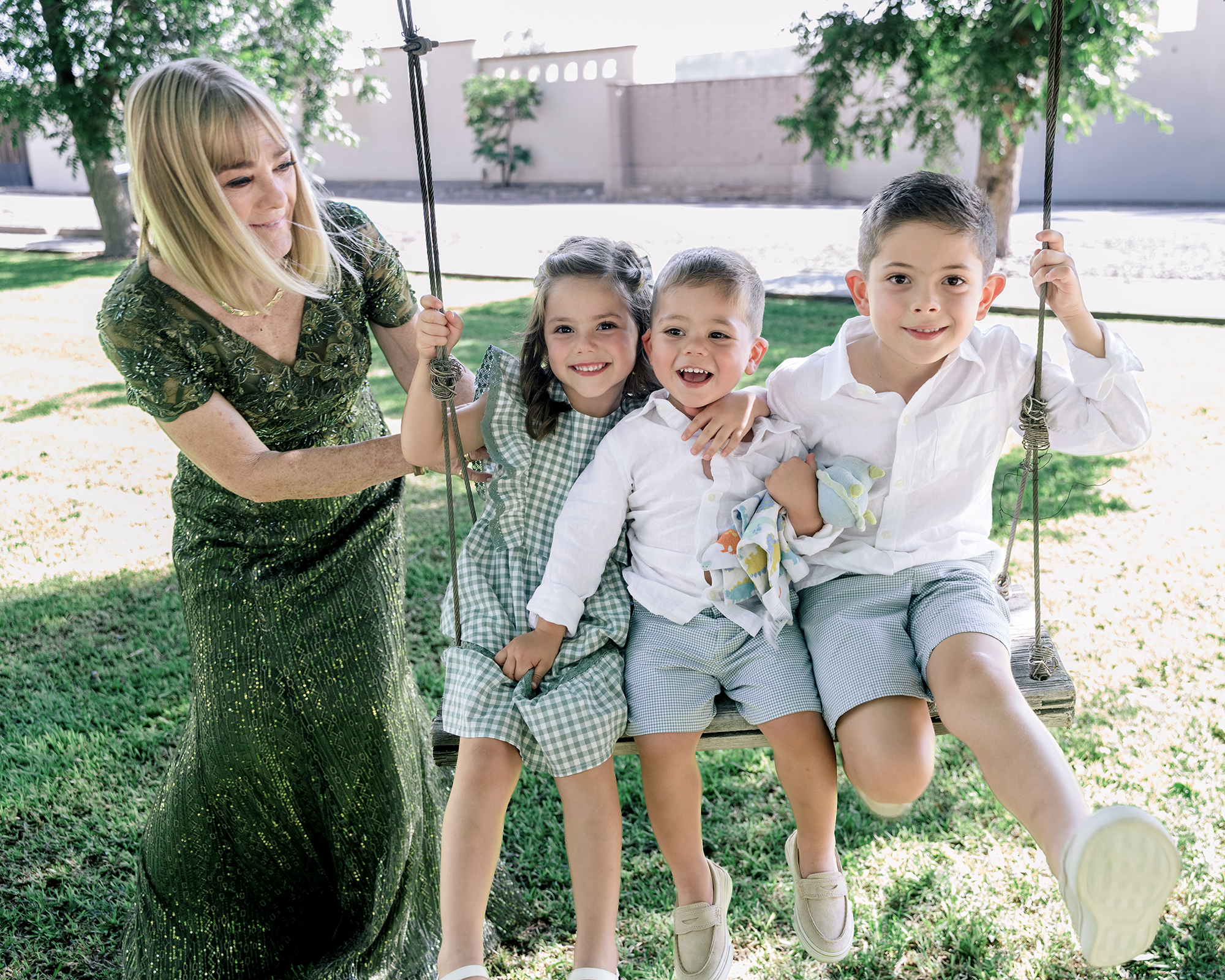 Candid wedding photo — grandmother with grandchildren on a swing, unscripted family moment captured by David Lack