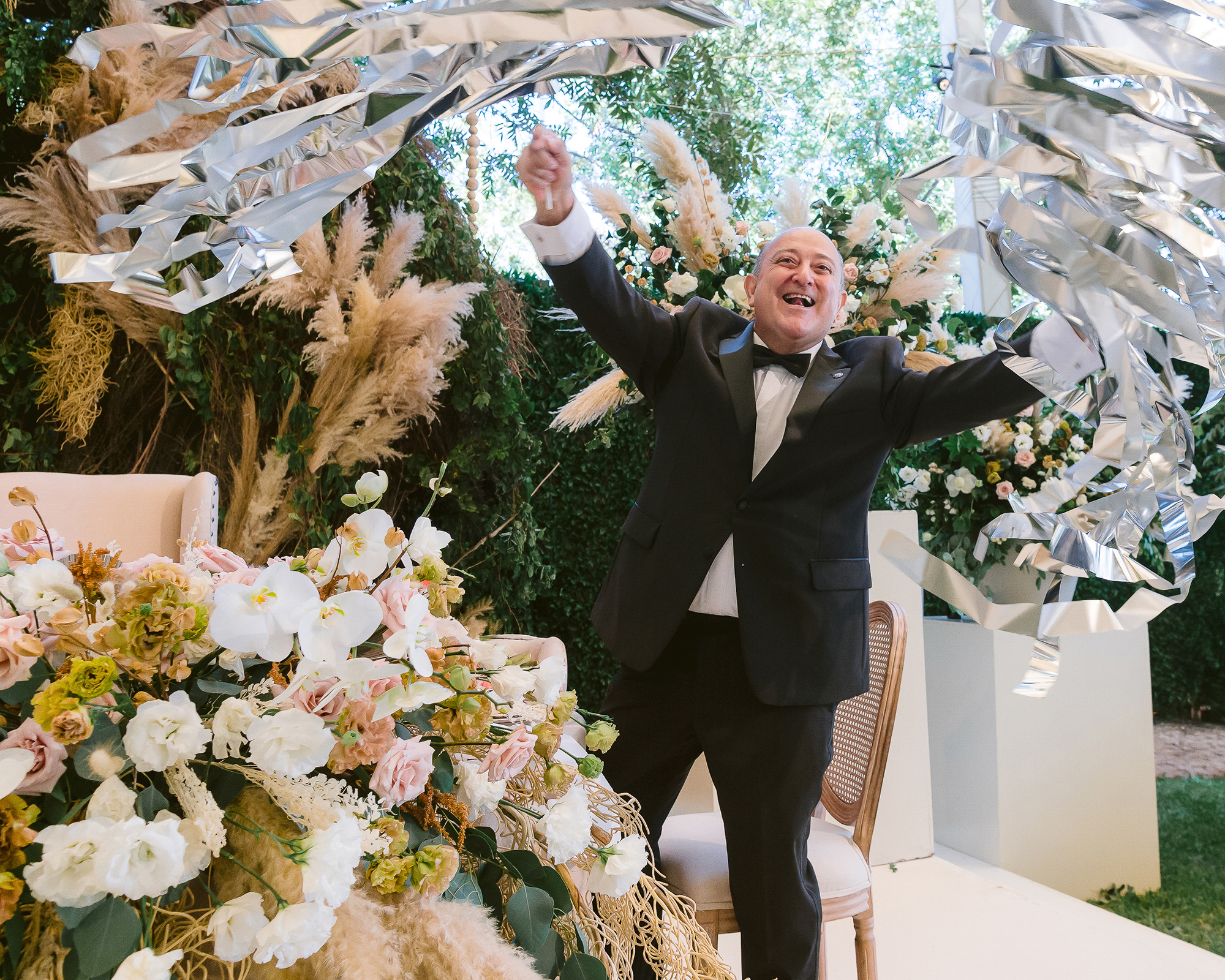 Candid guest moment at wedding reception — father of the groom celebrating with pinata, pure joy