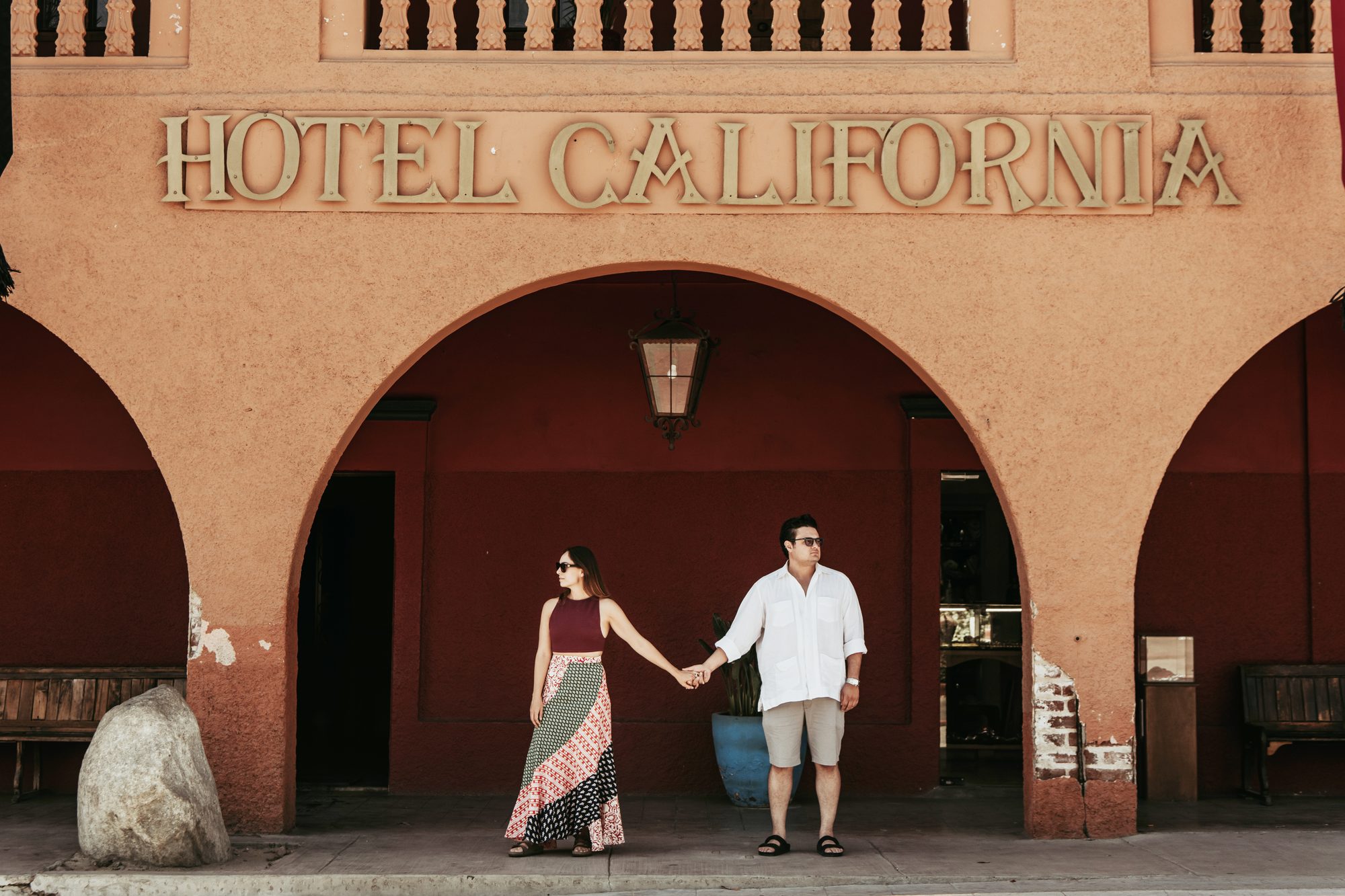Couple holding hands under the Hotel California arches in Todos Santos, Baja California Sur — David Lack